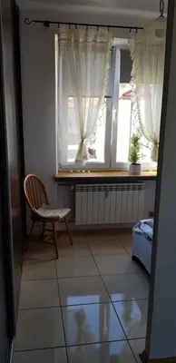 a room with a chair and two windows at Apartament Aga2 in Oświęcim