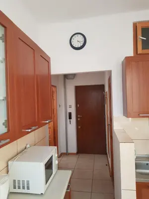 a kitchen with a microwave and a clock on the wall at Apartament Aga2 in Oświęcim