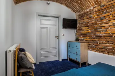 a bedroom with a brick wall and a white door at Apartamenty Bluma in Kraków