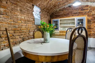 a table and chairs in a room with a brick wall at Apartamenty Bluma in Kraków