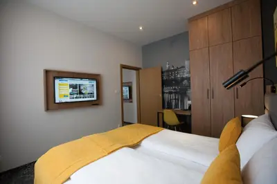 a bedroom with a bed with a tv on the wall at K4 APARTHOTEL KRAKÓW in Kraków