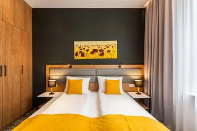 a bedroom with a large bed with yellow pillows at K4 APARTHOTEL KRAKÓW in Kraków