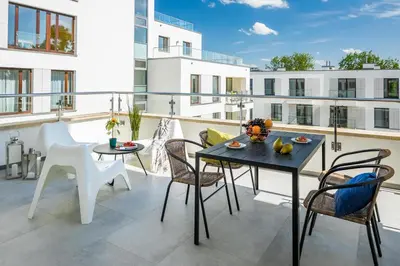 a patio with a table and chairs on a balcony at Vistula Boutique Exclusive Apartments in Kraków