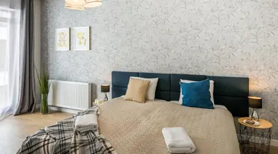 a bedroom with a blue bed with blue pillows at Vistula Boutique Exclusive Apartments in Kraków