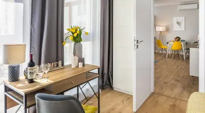 a room with a desk with a vase of flowers at Vistula Boutique Exclusive Apartments in Kraków