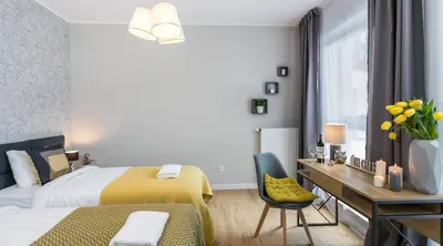 a bedroom with two beds and a desk and a chair at Vistula Boutique Exclusive Apartments in Kraków
