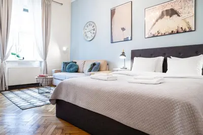 a bedroom with a large bed and a couch at Househost Apartment - Kupa 2 in Kraków
