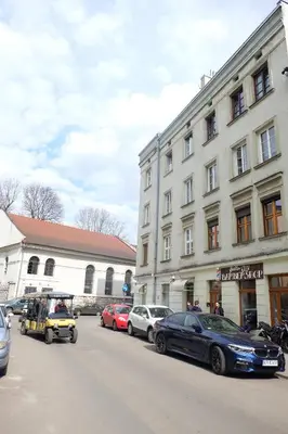 a street with cars parked in front of a building at Househost Apartment - Kupa 2 in Kraków
