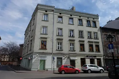 a white building with two cars parked in front of it at Househost Apartment - Kupa 2 in Kraków