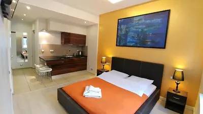 a bedroom with a bed and a bathroom with a sink at Mirror Gold & Grey Studios in Kraków