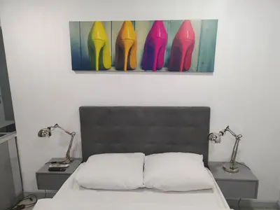 a bedroom with a bed with two lamps and a painting at Mirror Gold & Grey Studios in Kraków