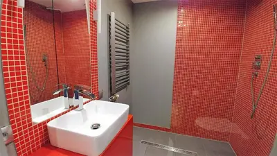 a bathroom with a sink and a shower with red tiles at Mirror Gold & Grey Studios in Kraków