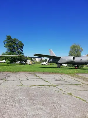 a plane sitting on the grass next to a field at Romantic Sky Apartment- 15th floor in Kraków