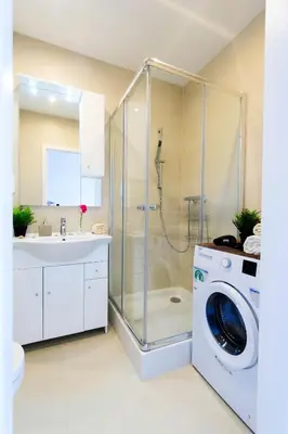 a bathroom with a shower and a washing machine at Romantic Sky Apartment- 15th floor in Kraków