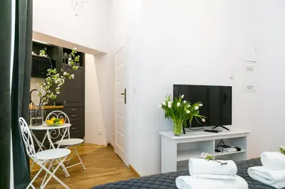 a small room with two beds and a table with a television at Way2Stay Old Town in Kraków