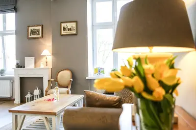 a living room with a couch and a table with yellow flowers at Way2Stay Old Town in Kraków