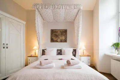 a bedroom with a large white bed with two towels at Way2Stay Old Town in Kraków