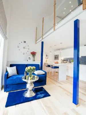 a living room with a blue couch and a table at Way2Stay Old Town in Kraków