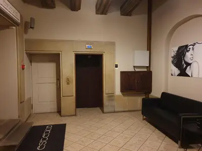a lobby with a black couch and a picture of a woman at SILENT Main Market Square with AC in Kraków