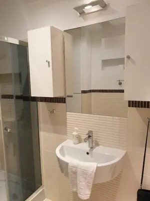 a bathroom with a sink and a glass shower at SILENT Main Market Square with AC in Kraków