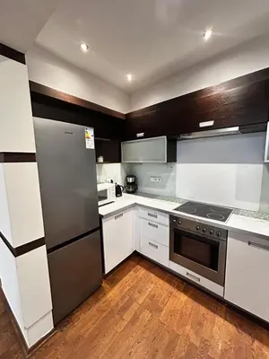 a kitchen with white cabinets and a stainless steel refrigerator at SILENT Main Market Square with AC in Kraków