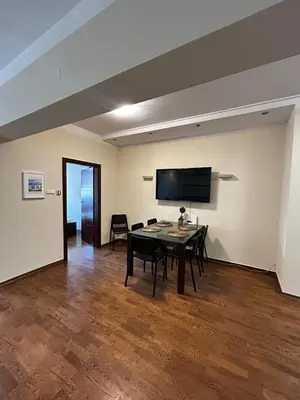 a dining room with a table and a flat screen tv at SILENT Main Market Square with AC in Kraków