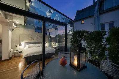 a glass room with a bed and a table with a lamp at Main Square Studio with TERRACE & Air condition in Kraków