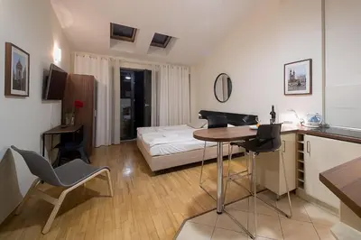 a kitchen and living room with a table and a bed at Main Square Studio with TERRACE & Air condition in Kraków