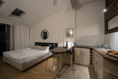 a bedroom with a bed and a kitchen with a table at Main Square Studio with TERRACE & Air condition in Kraków
