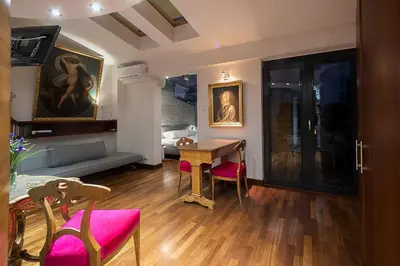 a living room with a table and pink chairs at Main Square Studio with TERRACE & Air condition in Kraków