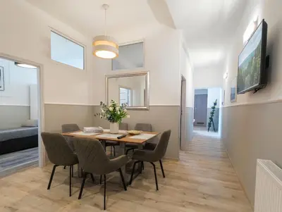 a dining room with a table with plates and glasses at Kings City - Sławkowska Apartments in Kraków