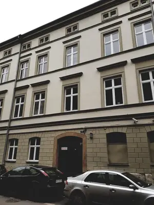 a building with two cars parked in front of it at Agnieszki 1 Apartment in Kraków