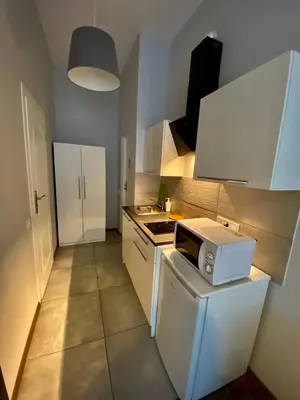 a small kitchen with a stove and a microwave at Ametyst Apartments in Kraków