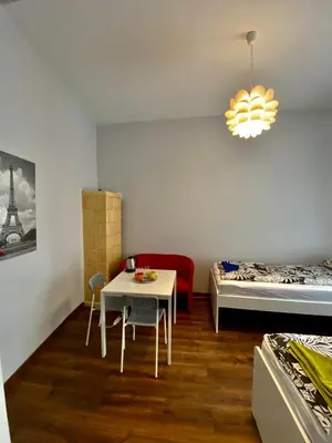 a room with a table and a bed and a table and chairs at Ametyst Apartments in Kraków