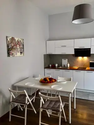 a kitchen with a white table and chairs and a table and chairsktop at Ametyst Apartments in Kraków
