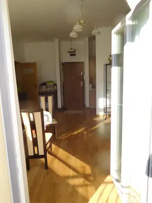 an empty living room with a table and a chair at Apartament DERUBEIS in Wieliczka
