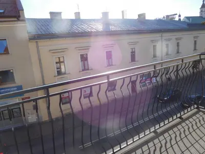 a view of a building behind a fence at Apartament DERUBEIS in Wieliczka