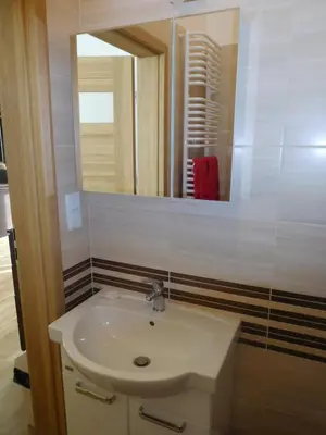 a bathroom with a sink and a mirror at Apartament DERUBEIS in Wieliczka