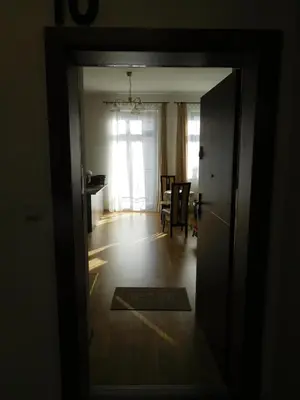 an open door to a living room with a table at Apartament DERUBEIS in Wieliczka