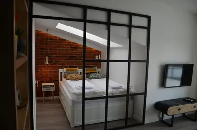 a bedroom with a bunk bed with a brick wall at Apartament Polka Dots in Kraków