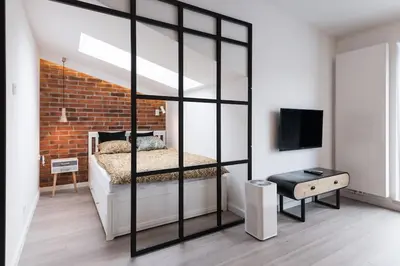 a bedroom with a bed and a brick wall at Apartament Polka Dots in Kraków