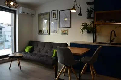 a living room with a couch and a table at Apartament Polka Dots in Kraków