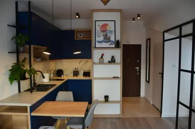 a kitchen with blue walls and a wooden table at Apartament Polka Dots in Kraków