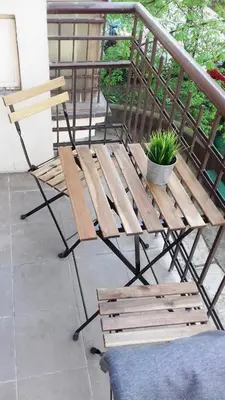 a wooden bench and a plant on a balcony at SL apartments in Kraków