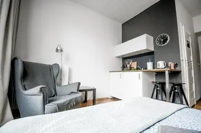 a bedroom with a bed and a chair and a table at SL apartments in Kraków