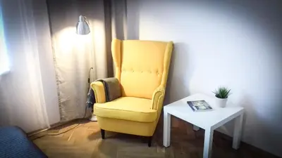 a yellow chair sitting next to a side table at SL apartments in Kraków