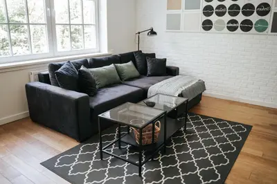 a living room with a black couch and a table at Ostoja in Rzyki