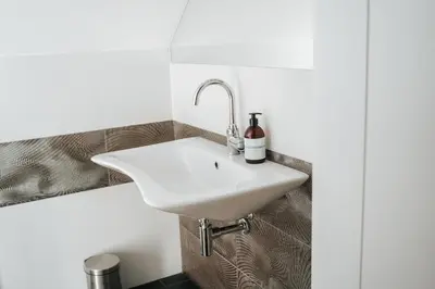 a bathroom with a white sink on the wall at Ostoja in Rzyki