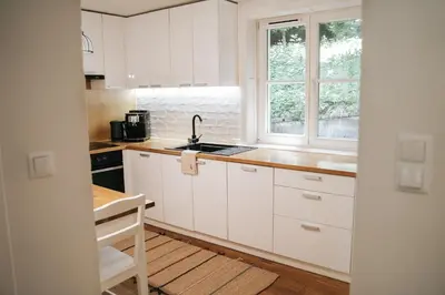 a kitchen with white cabinets and a sink and a window at Ostoja in Rzyki