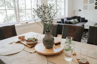 a dining room table with a vase with flowers on it at Ostoja in Rzyki